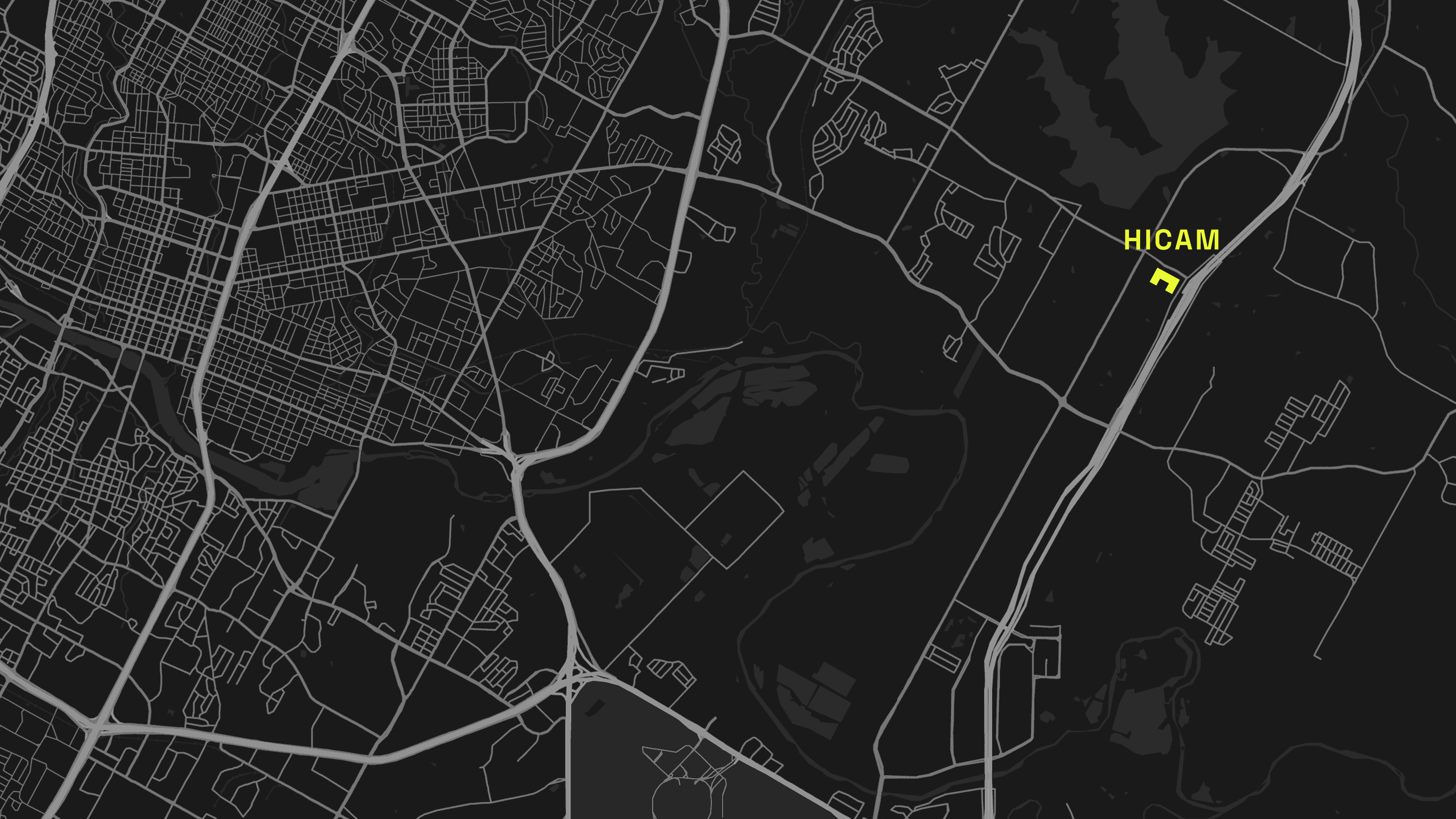Black and white city map highlighting road networks. "HICAM" is marked in yellow near a northeastern road, contrasting against the dark background.